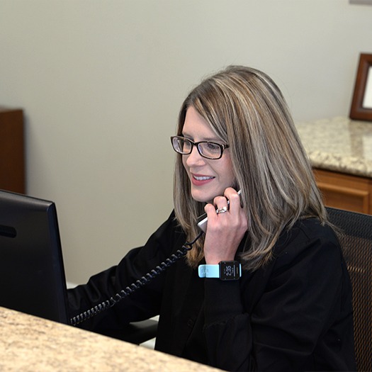 Smiling dental team member answering the phone