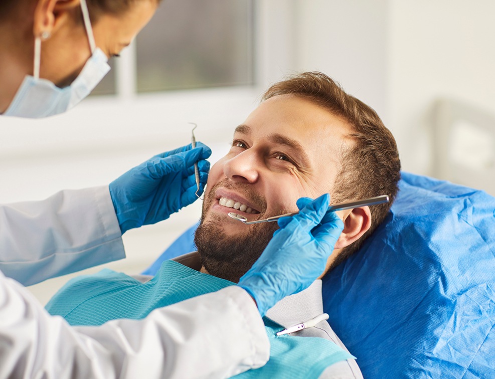 A dentist preparing to clean a man’s smile