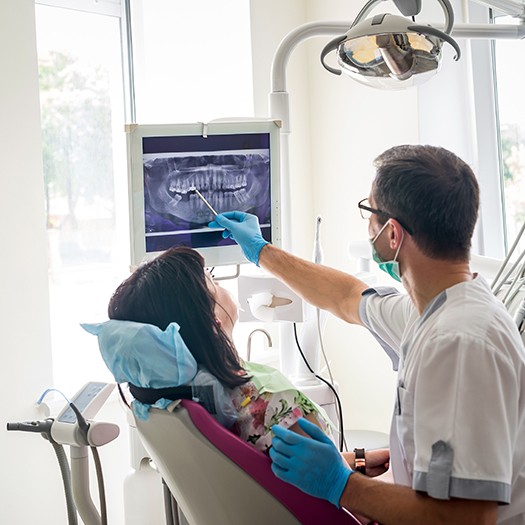 A dentist showing a dental X-ray to his patient