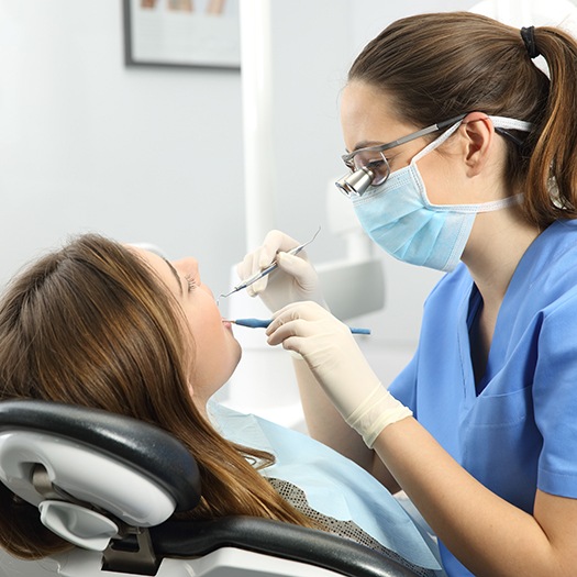 A dentist examining a woman’s mouth