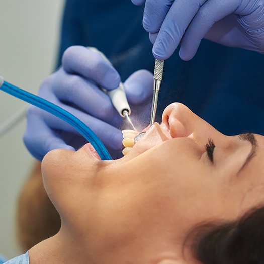 A dental hygienist cleaning a woman’s teeth