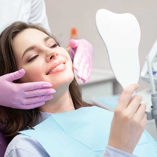 A woman admiring the results of cosmetic dentistry