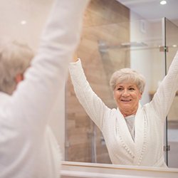 Woman smiling in her bathroom mirror