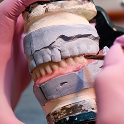 Lab technician creating a denture in the lab