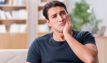 Man with toothache holding cheek