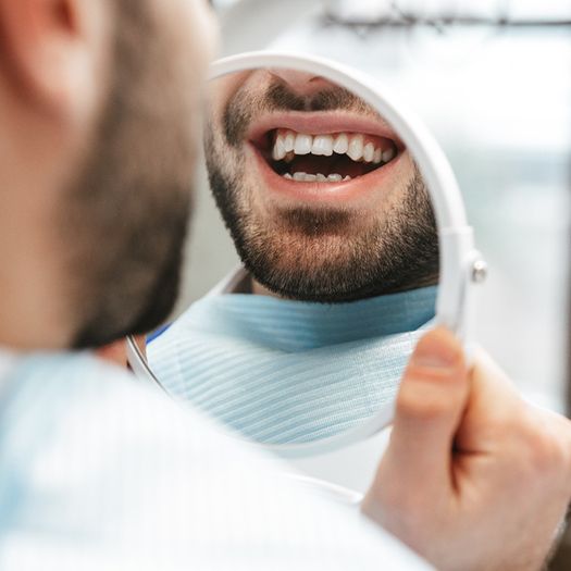 Patient looking at their smile in a mirror