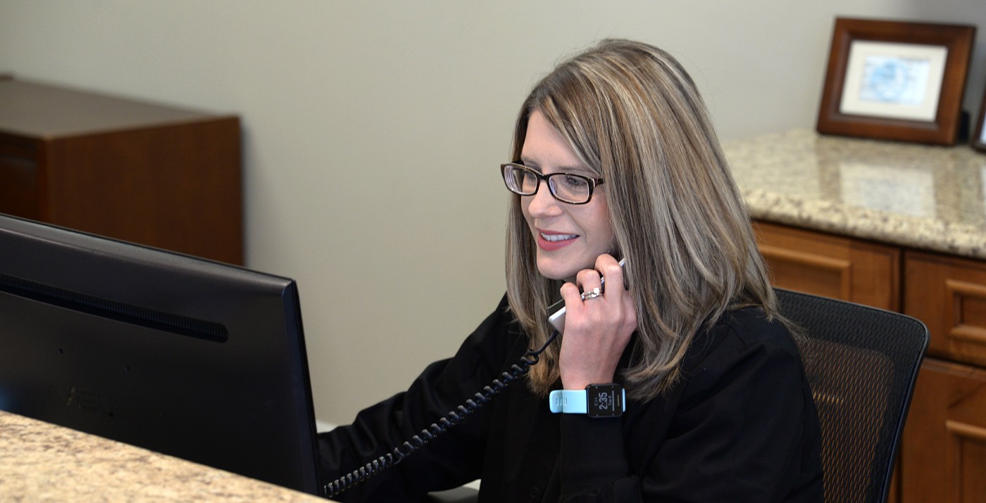 Smiling dental team member answering the phone