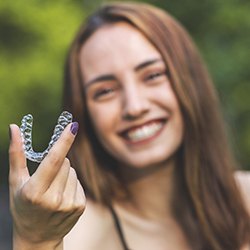 Woman holding Invisalign in Abingdon