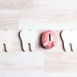 Teeth and a piggy bank, symbolizing the affordable cost of veneers in Abingdon